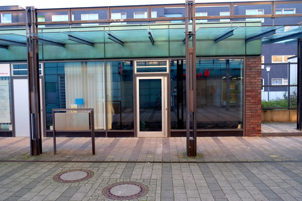 Leerstand - das Stadtteilzentrum von Berg Fidel verödet. Im leeren Schaufenster spiegelt sich noch die Leuchtreklame der geschlossenen Sparkassenfiliale. (6.12.2016; Foto: Klare)